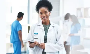 Michigan DNP nurse executive smiling with patient charts in hospital